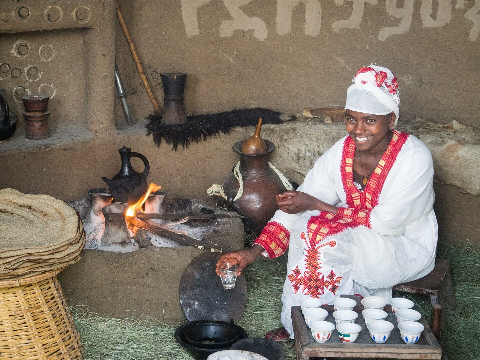 Eine Frau in traditioneller Kleidung bereitet die Kaffeezeremonie vor