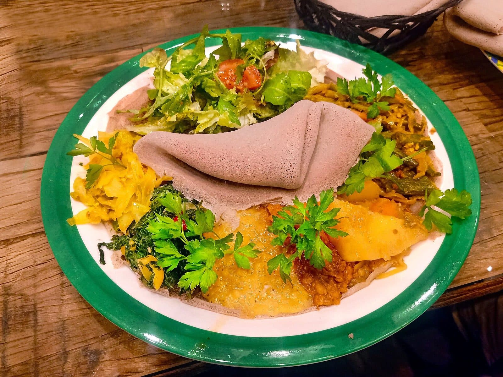 Vegane Platte mit verschiedenen Gemüsegerichten auf Injera