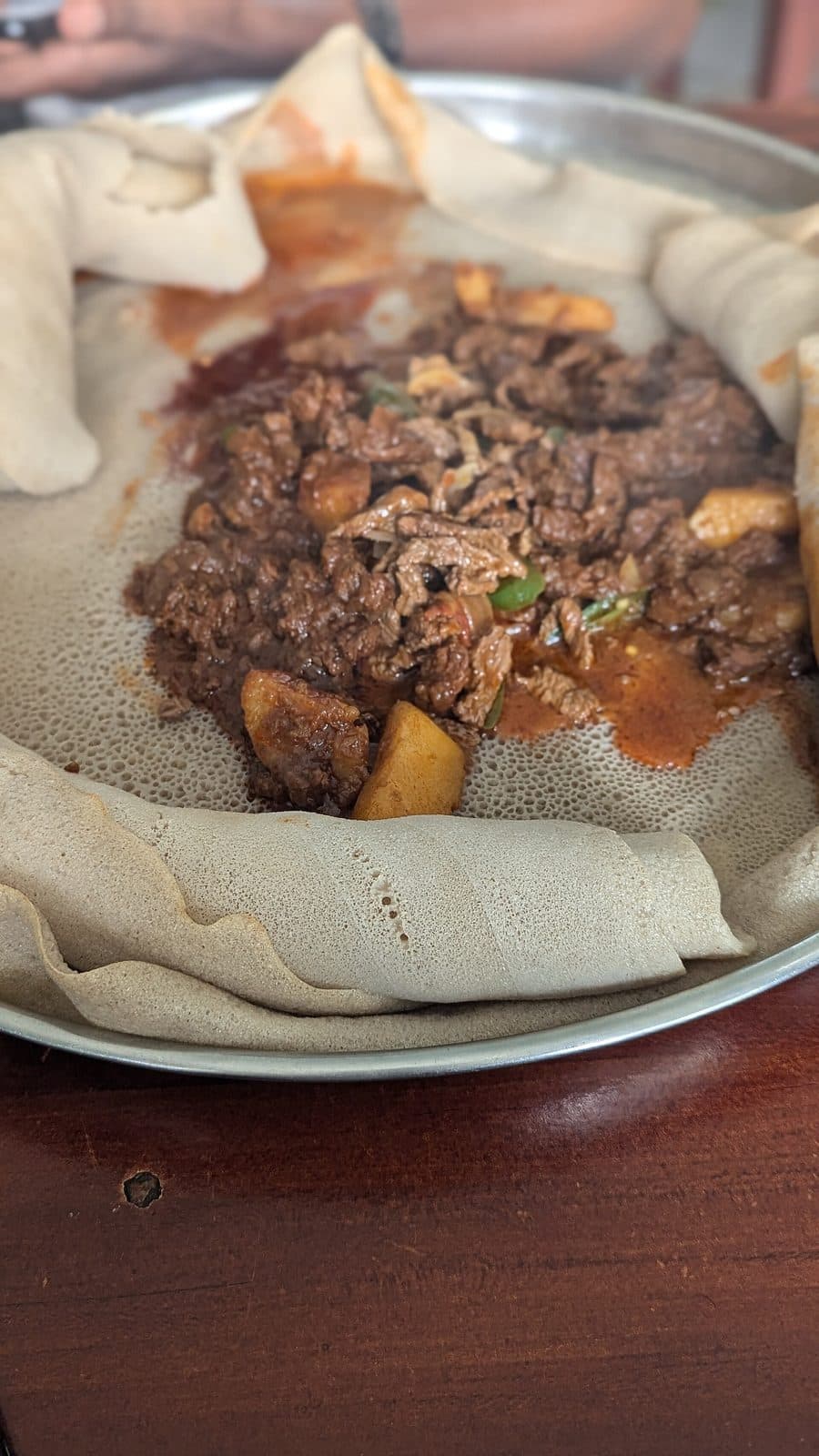 Doro Tibs - Hähnchenstücke mit Injera auf einem Teller