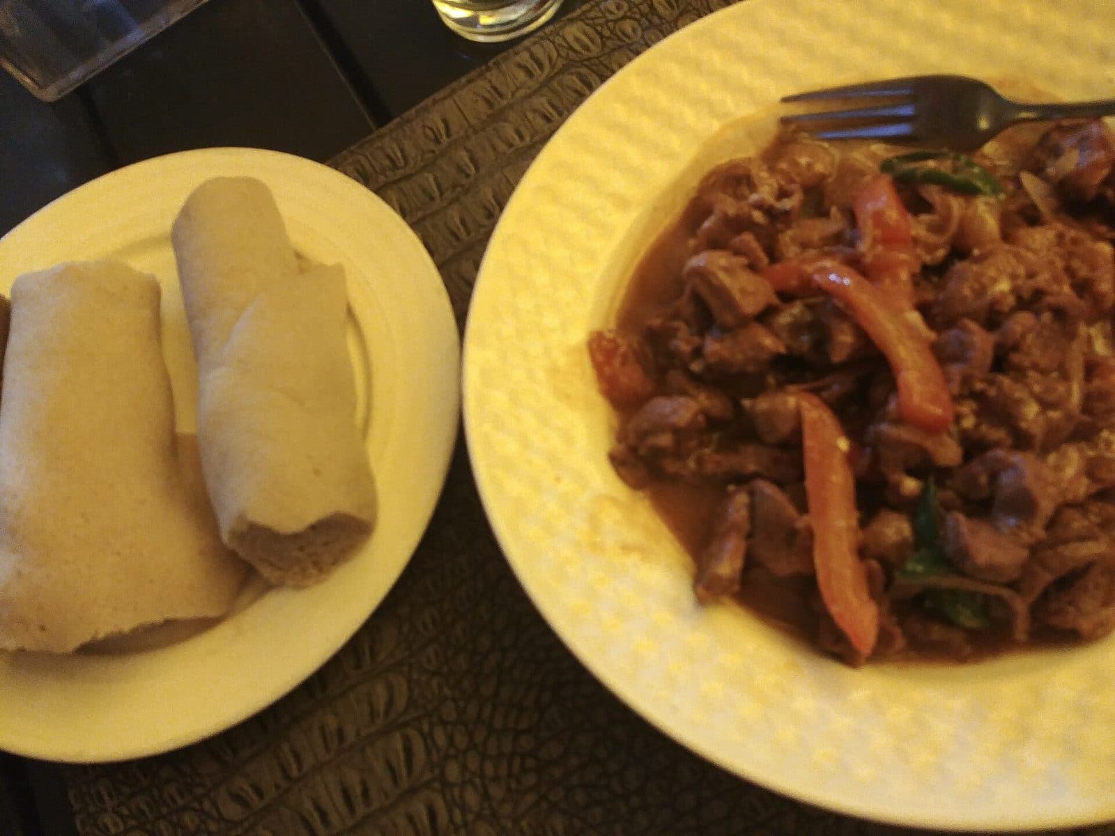 Lammtibs mit Injera auf zwei Tellern